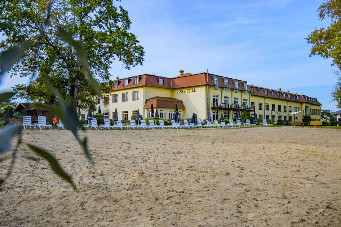 Ein Gebäude mit vielen Stühlen und Sonnenschirmen davor