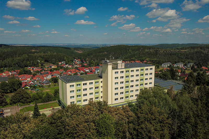 ein großes Gebäude mit vielen Fenstern und einer Stadt im Hintergrund