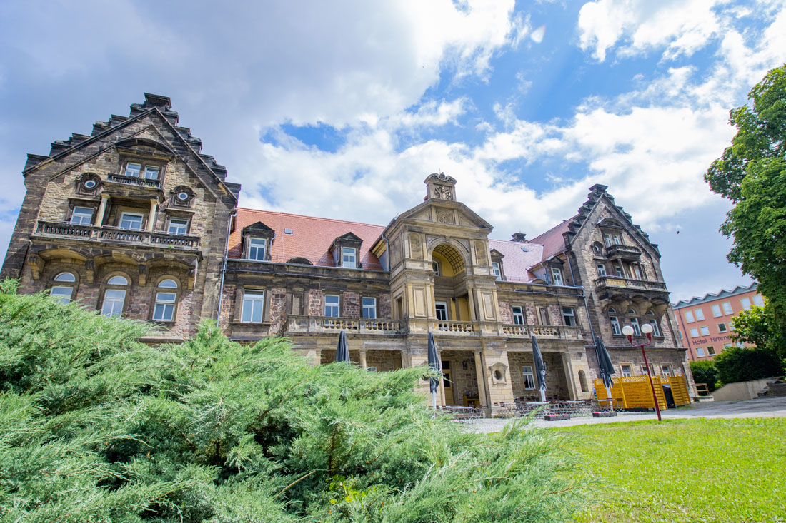 Ein großes Gebäude mit einem Rasen und Büschen