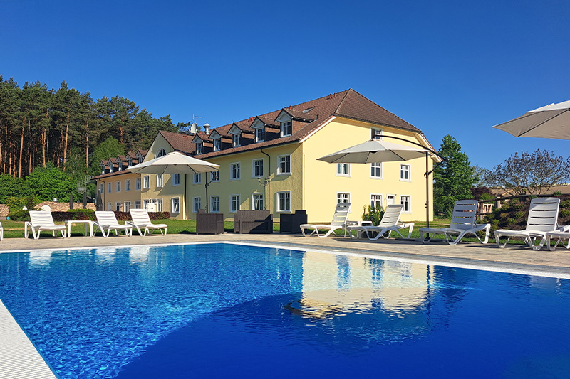 Ein Pool mit Stühlen und Sonnenschirmen vor einem Gebäude