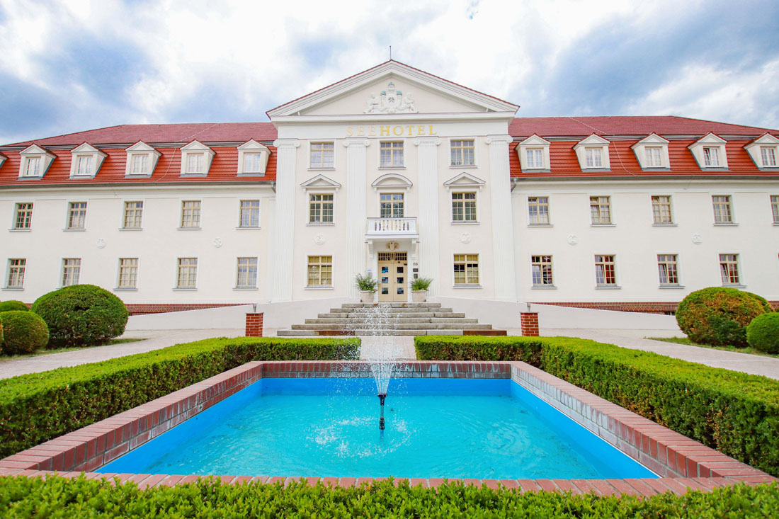 Ein Brunnen vor einem weißen Gebäude.